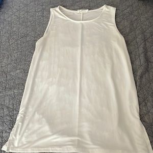 Cute stretchy white tank small but oversized. Long,hits mid thigh on me-I’m 5’1”